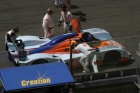 The bright orange helmet denotes that Harold Primat is aboard the #009 Lola.